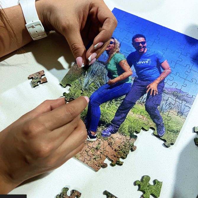 Persona armando un rompecabezas personalizado con una foto de pareja